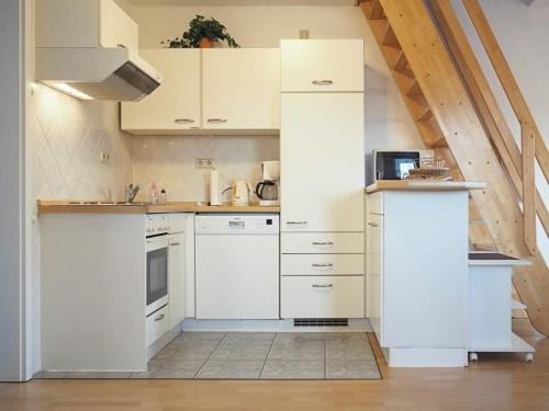 普雷罗Apartments Haus an der Stems 30 & 31的白色的厨房配有白色橱柜和电器