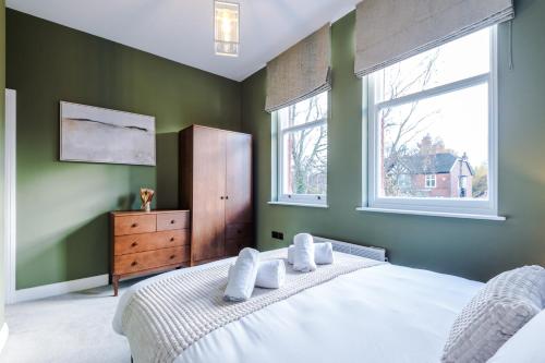 斯托克波特Hilltop Serviced Apartments - Stockport的卧室配有白色的床和2扇窗户。