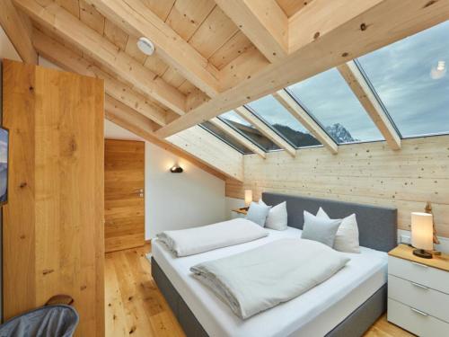 加尔米施-帕滕基兴Fewo Sterntaler DG mit Bergblick的一间带一张白色大床的卧室,位于带木制天花板的房间内