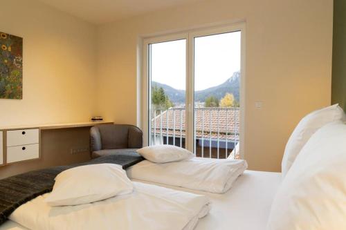 奥巴拉马高Ferienwohnungen Friedenshöhe in Oberammergau的卧室设有两张床和大窗户