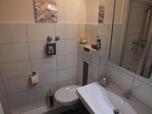 库克斯港Watten-Blick 1的白色的浴室设有卫生间和水槽。