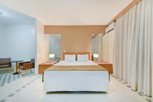 库亚巴Hotel Nacional Inn Cuiabá的一间卧室配有一张大床和一张书桌