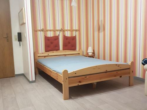 SchweiburgNEU! Fewo Küstenstube的木床,带条纹墙的房间