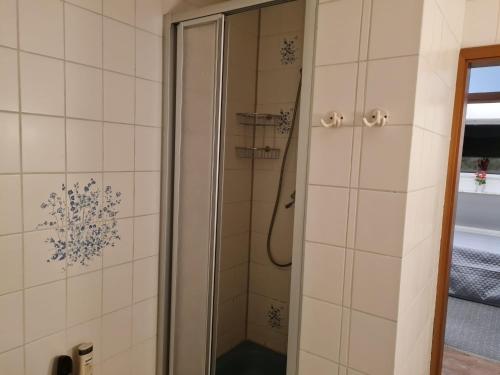 HeeslingenNEU! Ferienwohnung zum Anker的浴室铺有白色瓷砖,设有淋浴。