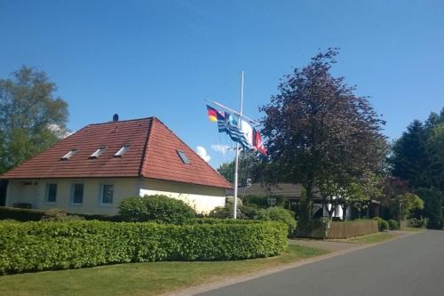 HeeslingenNEU! Ferienwohnung zum Anker的前面有两面旗帜的房子