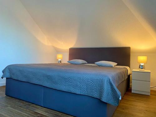 瓦尔斯罗德NEU Ferienwohnung Walsrode的一间卧室配有一张带两盏灯的蓝色床。