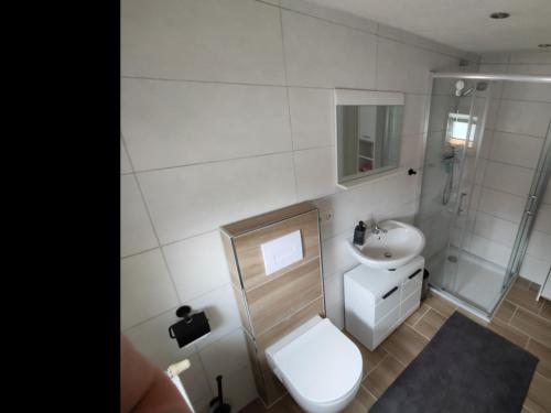 BundeNEU Ferienwohnung Wildgans Dollart Ostfriesland的白色的浴室设有卫生间和水槽。