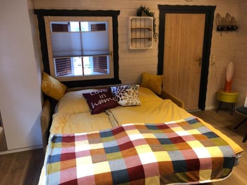 SchöningenNEU! Ferienhütte Tiny House的一间卧室配有一张带彩色毯子的床
