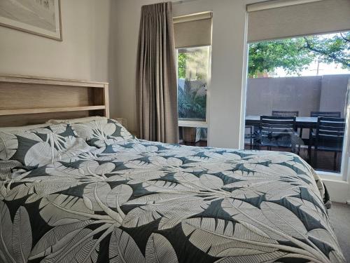 阿德莱德North Adelaide Apartment的一间卧室配有一张带花卉棉被的床