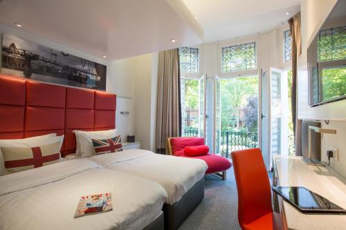 伦敦亨利大厦酒店的一间卧室设有一张大床和红色床头板