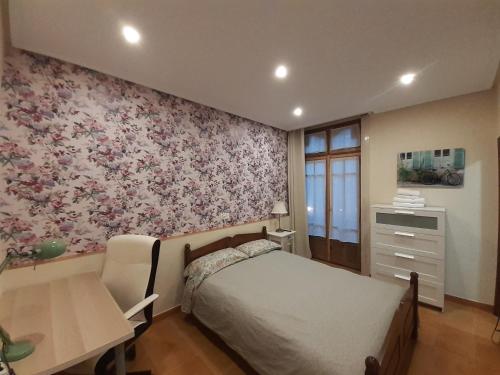 奥维多Uría 25 rooms的一间卧室配有一张床、一张桌子和一张桌子