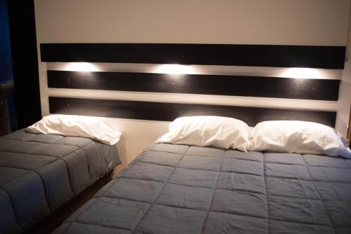 瓜伊马延Hostel Los Andes的一间卧室配有一张带黑白床头板的床