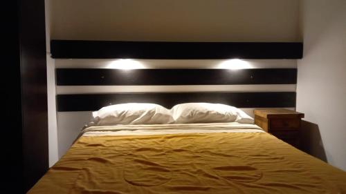 瓜伊马延Hostel Los Andes的一间卧室配有一张带黑白床头板的床