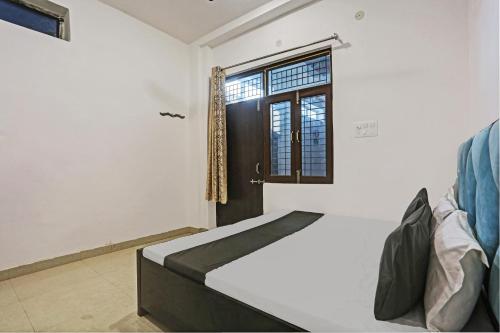 坎普尔SPOT ON Shree Sarveshwar Party Lawn And Hotel的一间卧室设有一张床和一个窗口