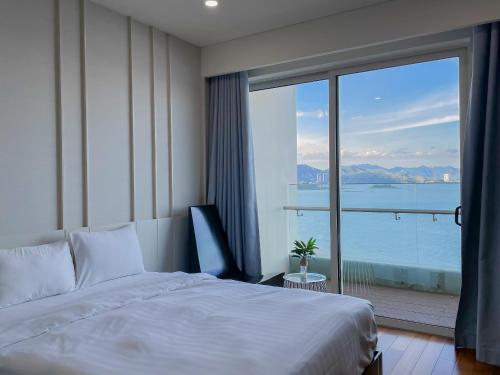 芽庄The Sea Luxury Nha Trang Apartment的酒店客房设有一张床和一个大窗户