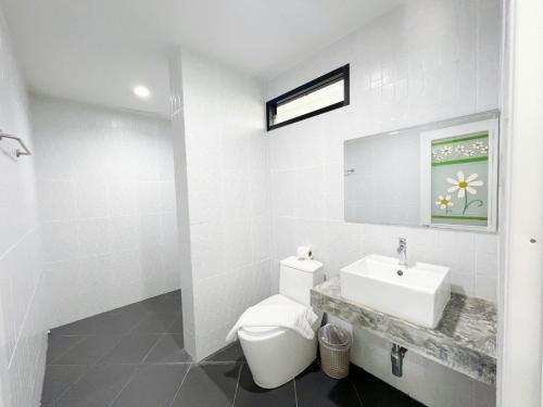 拉威海滩Natthawan Pool Access Rawai的白色的浴室设有卫生间和水槽。