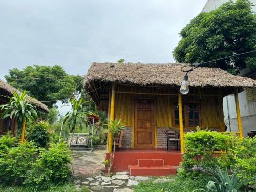 宁平Ninh Binh Bamboo Farmstay的茅草屋顶的黄色小房子