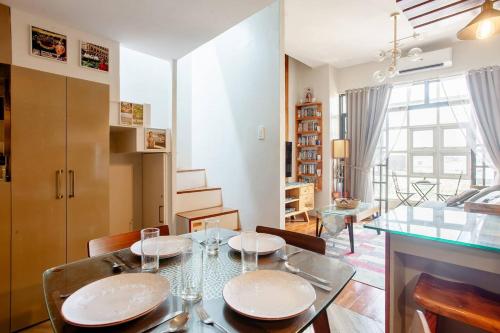 卡利博Lovely Loft Apartment in Kalibo, Aklan的一间带桌椅的用餐室和一间客厅