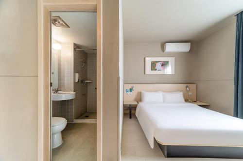 上海麦新格精品酒店(上海浦东国际机场店)的一间带白色床的卧室和一间浴室
