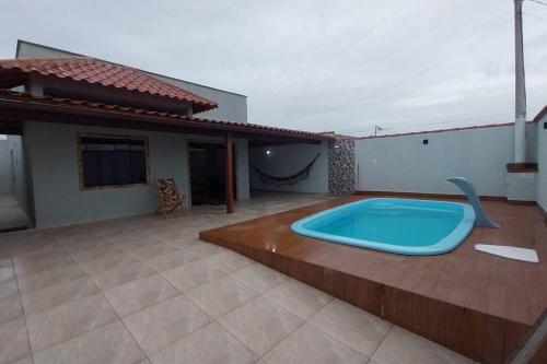 阿拉亚尔-杜卡布Casa de Temporada no Paraíso de Arraial do Cabo的一座房子旁边的甲板上的大型热水浴缸