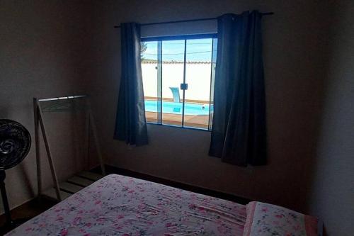 阿拉亚尔-杜卡布Casa de Temporada no Paraíso de Arraial do Cabo的一间卧室设有享有泳池景致的窗户