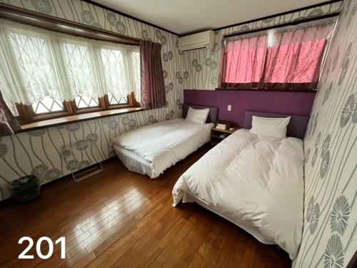 东京冠京ホテル的一间卧室设有两张床和两个窗户。