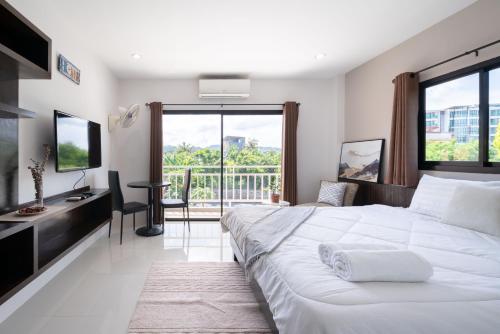 Ban Bo HanSD Residence I Naiyang Beach I HKT Airport的卧室配有一张白色大床和一张书桌