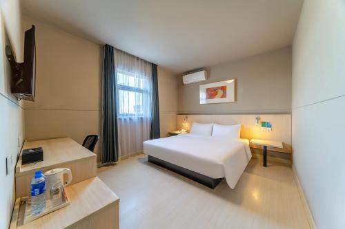 上海麦新格精品酒店(上海浦东国际机场店)的酒店客房设有白色的床和窗户。
