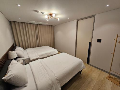 仁川市Miracle Suite house 201 pool villa的一间卧室设有两张床和天花板