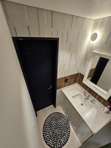 仁川市Miracle Suite house 201 pool villa的浴室设有黑色的门和水槽。