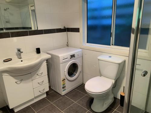 亚斯Very Comfortable Granny Flat的浴室配有卫生间水槽和洗衣机。