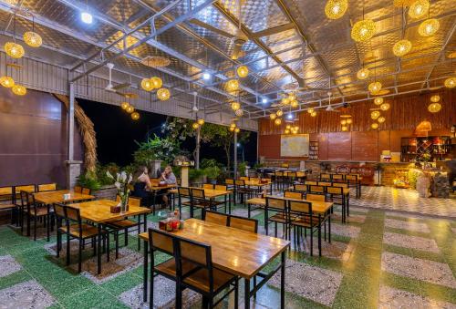 吉婆岛Green Homestay的餐厅设有木桌和椅子及灯