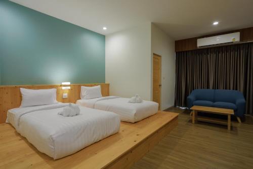 Ban PhayomMOODs Boutique Hotel的酒店客房,设有两张床和一张蓝色椅子