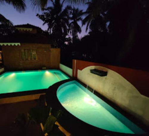 马尔万Blue Sea Beach Resort Malvan的夜间游泳池,带水滑梯