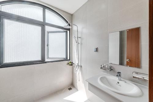 富国222 ROSÉ Hotel的白色的浴室设有水槽和窗户。