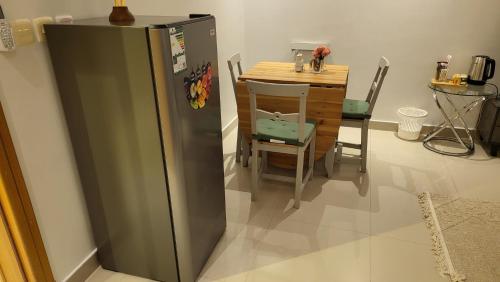 利雅德شقة فاخرة VIP حي الوادي的厨房配有小桌子和冰箱。