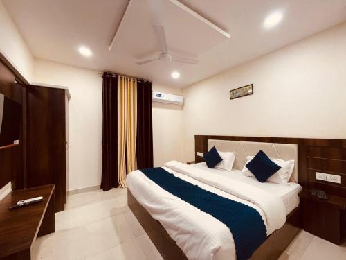 哈里瓦The White House Haridwar的一间卧室配有一张带蓝色枕头的大床