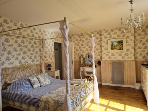 Ansac-sur-Vienne福乐尔德里斯酒店的一间卧室配有一张天蓬床和一张书桌