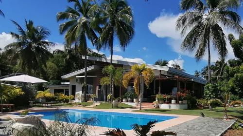 Seaview Residence Garden的一座带游泳池和棕榈树的房子