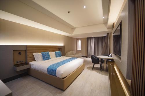 马尼拉Bayprime Hotel的配有一张床和一张书桌的酒店客房