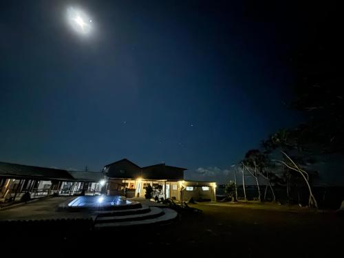 维拉港Bluepango Guest House的天空中月亮的建筑的夜视