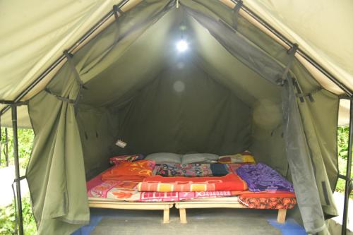卡索尔Himtrek Riverside Camps, Kasol的绿色帐篷内的一张床位