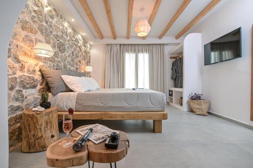 纳克索乔拉Naxos Finest Hotel & Villas的一间卧室配有一张床、一张桌子和一台电视。