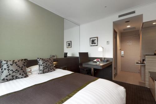 埼玉市皇宫大宫酒店的酒店客房配有一张床、一张书桌和一间厨房。