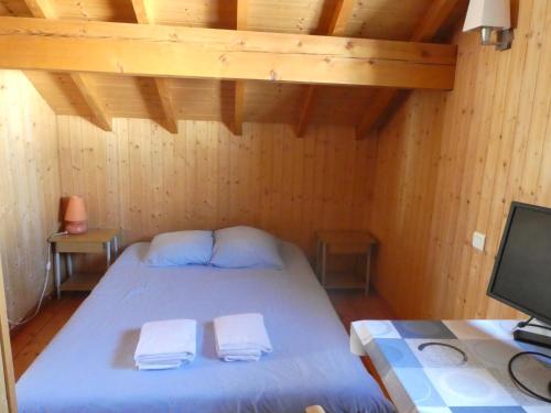 沙佩尔代布瓦Chalet Beaujon Chapelle-des-Bois的一间卧室配有一张床,上面有两条毛巾
