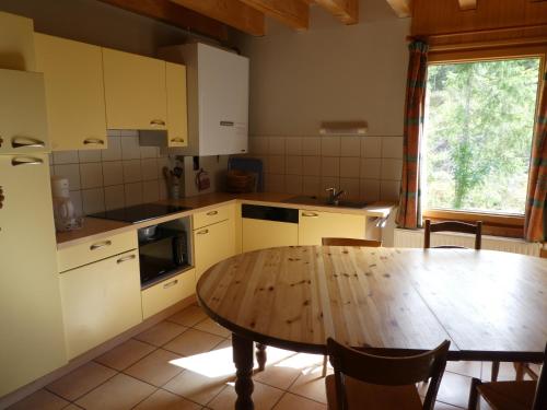 沙佩尔代布瓦Chalet Beaujon Chapelle-des-Bois的厨房配有木桌和桌子,还设有用餐室。