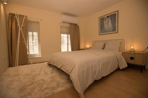 耶路撒冷Historic 4-Bedroom Gem with Private Garden, Steps from Old City & Mamila Complex的卧室配有白色的床和2扇窗户。