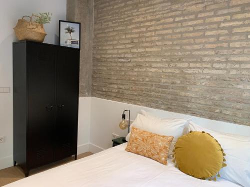 瓦伦西亚La Reina Beach rooms的一间卧室设有砖墙和一张床
