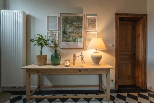 罗什福尔Maison Comtale的一张桌子,上面有台灯和植物