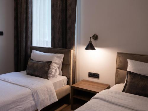 新帕扎尔Hotel RAS Pazarište的酒店客房设有两张床和一张桌子。